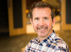 Don Endres A man with a beard and plaid shirt smiling.